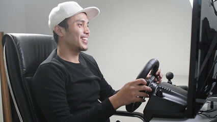 happiest Casual Asian young man playing racing game simulation