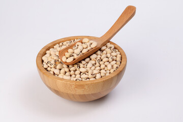 Blackeye beans in wooden bowl scoop spoon on white background