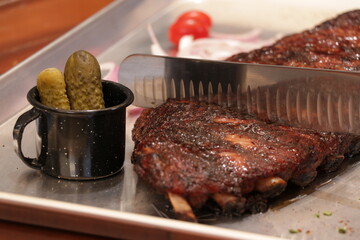 slicing grilled pork bbq ribs with pickles