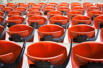 Empty red seats, grandstand with plastic seats, chairs for fans on a sports stadium, lockdown no spectators allowed