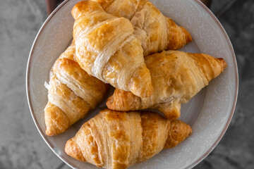 A plate of delicious golden, warm miniature croissants, photographed up close, in Toronto, Ontario, Canada, February 2021. 