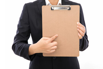 The female staff in front of the white background is wearing formal clothes, holding a blank file hard board clip