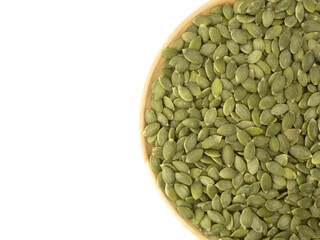 Organic pumpkin seeds on wooden plate isolated top view on white background for pumpkin seeds can improve health concept.