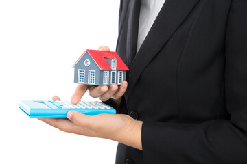 The house salesman uses a calculator to calculate the house price with a small house model in hand