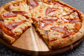 Pepperoni pizza, on a black textured background. Italian food concept. Close-up.