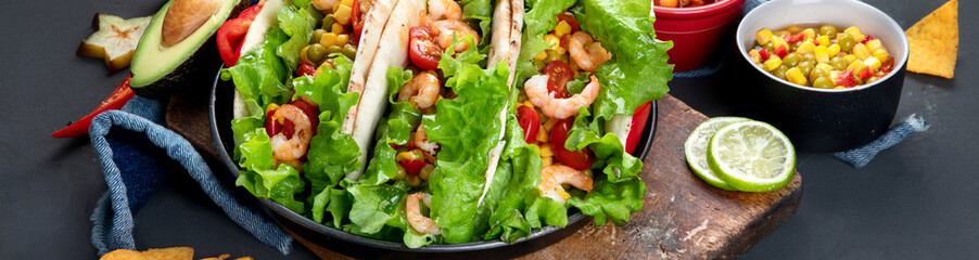 Hispanic mexican food, meat tacos with shrimps on dark background