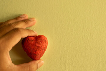 Heart shaped foam held by hand on a green background, suitable for Valentine's Day.