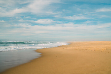 Fototapeta na wymiar Wide sandy beach, blue sea, and beautiful cloudy sky.