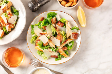 Caesar salad, top shot on a white marble background with a place for text