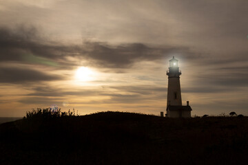 Yaquina Head Lighthouse built in 1873, with golden sunset - Oregon, USA