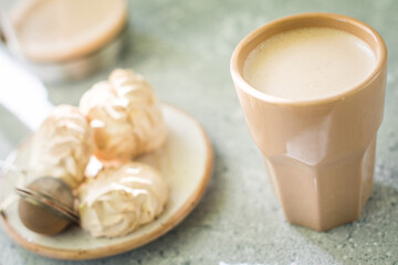 A drink in a ceramic glass and a cake on the table. Nice breakfast.