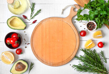 Mockup with empty wood cutting board. Fresh vegetables and ingredients for cooking on white wooden background. Food background with copy space.