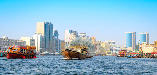 Fishing boat in Dubai, against the backdrop of the city.