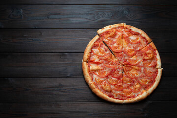 Delicious classic Italian pizza with tomatoes on a dark wooden background