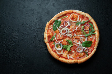 Tasty appetizing vegetarian pizza on dark stone background, top view, space for text