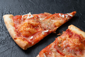 Tasty appetizing vegetarian pizza on dark stone background, top view 