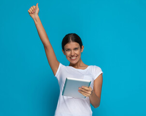 casual woman celebrating succes with her tablet in her hands