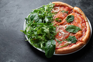Tasty appetizing vegetarian pizza on dark stone background, top view 