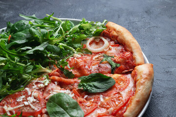 Tasty appetizing vegetarian pizza on dark stone background, top view 