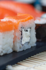 Sushi rolls with salmon, rice, greens and soy sauce