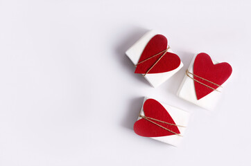 The concept of the background to Valentine's Day. Three white boxes with hearts lie on a white background. Copying space