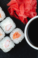 Sushi rolls with salmon, rice and soy sauce