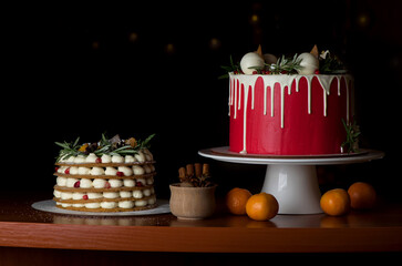 Homemade tasty whole round cake with white cream, black cookies on black wooden selective focus