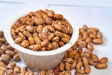Closeup of cranberry beans in a white porcelain bowl, healthy and organic legumes