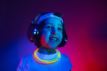 cyberpunk boy child in a white T shirt and large headphones listening to music on the background of...