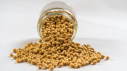 Closeup of dried soybeans on the table and in glass on white background, healthy food