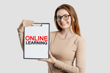 online learning. Beautiful young business woman wearing glasses holds a clipboard with mock up...