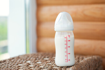 Bottle with breast milk for baby on wooden background. Maternity and baby care concept. Top view. Free copy space. - 411727917