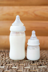 Bottles with breast milk for baby on wooden background. Maternity and baby care concept. Top view. - 411728123