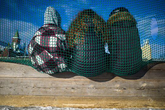Stockholm, Sweden  Weekend ice skaters on the Ostermalms IP ice rink and three kids relaxing in a net.