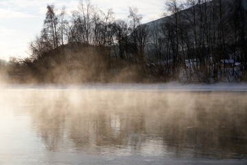 The river is about to freeze. It is very cold and the river is much warmer than the air, therefore the smoke or the damp from the river. Shot at Gol, Norway in February. Minus 20 degreases Celsius.  © SteinOve
