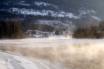 The river is about to freeze. It is very cold and the river is much warmer than the air, therefore the smoke or the damp from the river. Shot at Gol, Norway in February. Minus 20 degreases Celsius.  © SteinOve