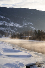 The river is about to freeze. It is very cold and the river is much warmer than the air, therefore the smoke or the damp from the river. Shot at Gol, Norway in February. Minus 20 degreases Celsius. 