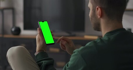 shopping online by smartphone, man is swiping display on website of online shop, green screen on gadget for compositing - Powered by Adobe