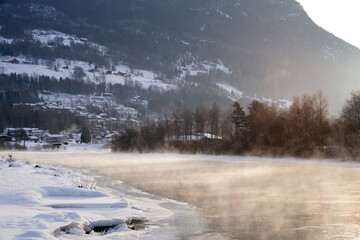 The river is about to freeze. It is very cold and the river is much warmer than the air, therefore the smoke or the damp from the river. Shot at Gol, Norway in February. Minus 20 degreases Celsius.  © SteinOve