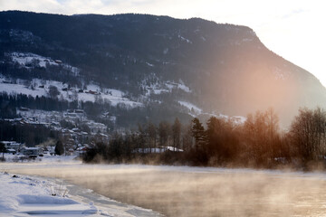 The river is about to freeze. It is very cold and the river is much warmer than the air, therefore the smoke or the damp from the river. Shot at Gol, Norway in February. Minus 20 degreases Celsius.  © SteinOve