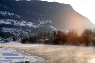 The river is about to freeze. It is very cold and the river is much warmer than the air, therefore the smoke or the damp from the river. Shot at Gol, Norway in February. Minus 20 degreases Celsius.  © SteinOve