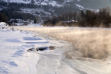 The river is about to freeze. It is very cold and the river is much warmer than the air, therefore the smoke or the damp from the river. Shot at Gol, Norway in February. Minus 20 degreases Celsius.  © SteinOve