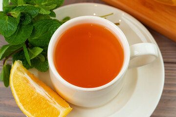Cup of tea served with lemon and mint