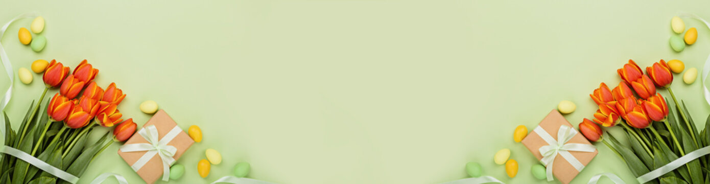 Stylish background with colorful easter eggs pastel colors isolated on green background. Horizontal long banner for web design. Flat lay, top view, mockup, overhead, template