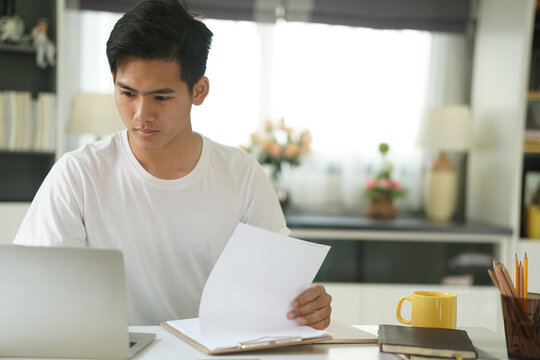 Asian Young Student Man Entrepreneur Working With Computer Studying Learning Online At Home. E-learning Webinar Meeting. Social Distance In Covid Pandemic