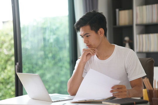 asian young student man entrepreneur working with computer studying learning online at home. e-learning webinar meeting. social distance in covid pandemic