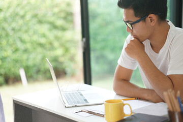 asian young student man entrepreneur working with computer studying learning online at home....