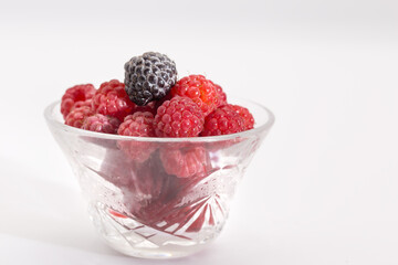 Raspberry berries in a vase on a white background.