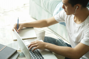 asian young student man entrepreneur wear earphones working with computer studying learning online...