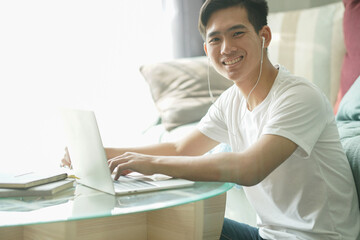asian young student man entrepreneur wear earphones working with computer studying learning online...
